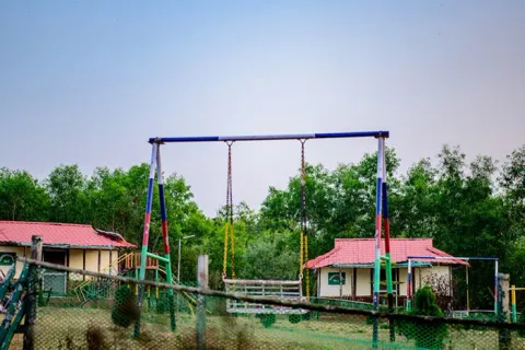 Open recreation ground surrounded by forest hills