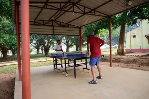 Visitors playing table tennis in an outdoor covered area